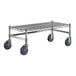 A Regency chrome plated metal dunnage rack with black wheels.