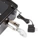A close-up of a black and silver Tor Rey digital crane scale with a metal hook.