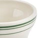 A white china bowl with a green striped border.