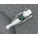 A close-up of a Bobrick deck mounted liquid soap dispenser with a metal faucet and green top.