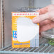 A hand holding a box of Arm & Hammer Fridge-N-Freezer Baking Soda