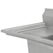 A close-up of an Advance Tabco fabricated three compartment pot sink with two drainboards.