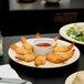 A plate of fried shrimp with sauce on a Thunder Group tan melamine plate.