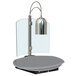 A Hatco silver carving station lamp on a grey round table.
