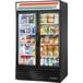 A True refrigerated glass door merchandiser with a variety of products.
