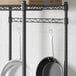 A black metal Regency hanger rail with black bars holding pans.