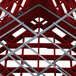 A red Vollrath Traex plate rack with metal bars.