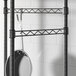 A black metal Regency hanger rail with a pan hanging from it.