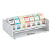 A Noble Products white dispenser holding 7 rolls of different colored labels with days of the week.