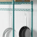 A Regency green epoxy hanger rail holding pans.