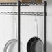 A Regency black metal hanger rail holding pans.