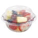 A clear plastic container with a clear plastic lid filled with fruit.