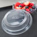 A plastic container with a lid holding a bowl of strawberries and blueberries.
