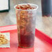 A clear plastic Choice plastic cup with ice and a drink in it.