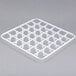 A white plastic tray with square holes.