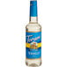 A close-up of a Torani Sugar-Free Vanilla Flavoring Syrup bottle with a blue label.