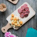 A cutting board with cheese and meat on it with Choice Patty Paper packaging on the table.