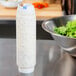 A FIFO Innovations squeeze bottle of white liquid next to a bowl of salad.