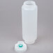 A white plastic bottle with a green cap and a thin black valve.