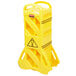 A yellow plastic Rubbermaid safety barrier with a warning sign.