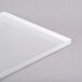 A white rectangular Eastern Tabletop tempered glass shelf on a gray surface.