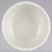 A Tuxton eggshell white china bowl with a white rim.