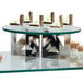 An Eastern Tabletop round acrylic display shelf with desserts on it in a bakery display.