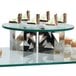 An Eastern Tabletop round tempered glass display shelf holding a group of desserts.