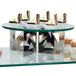 A round tempered glass display shelf with desserts on it.