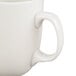 A close-up of a CAC Camptown ivory china mug with a handle.