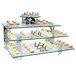 A rectangular glass buffet shelf with lemon desserts on it.