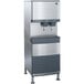 A silver and black Follett 110 FB Series freestanding water cooled ice machine with water dispensers.