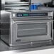 An Amana stainless steel commercial steamer microwave oven on a counter.