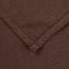 A close up of a brown fabric with a small hole in it.