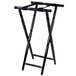 A black wooden Lancaster Table & Seating folding tray stand with turned legs.