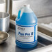 A blue bottle of Noble Chemical Pan Pro II liquid detergent on a metal sink.