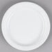 A Tuxton Colorado bright white narrow rim china plate on a gray surface.