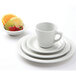 A Tuxton Colorado white plate with a bowl of fruit including strawberries and lime slices.