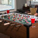 A man playing the Atomic Gladiator Foosball game with a wooden handle.