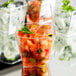 A group of Fineline clear plastic tumblers filled with food on a table.