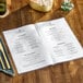 A clear menu cover on a table in a farm-to-table restaurant.