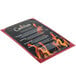 A Menu Solutions burgundy menu board with a red frame holding a menu with text and flames.