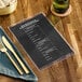 A clear menu cover on a table in a farm-to-table restaurant.