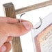 A person holding a Menu Solutions antiqued wood table tent with rings.