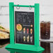 A teal wood flip top table tent with a menu inside.