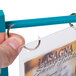 A hand holding a Sky Blue wood flip top table tent with a plastic card inside.