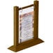 A Menu Solutions walnut wood flip top table tent with a menu inside on a table.