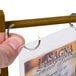 A hand holding a walnut wood table tent sign with paper inside.