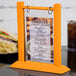 A Menu Solutions Mandarin wood table tent holding a menu.