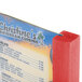 A red wooden Menu Solutions table tent on a table.